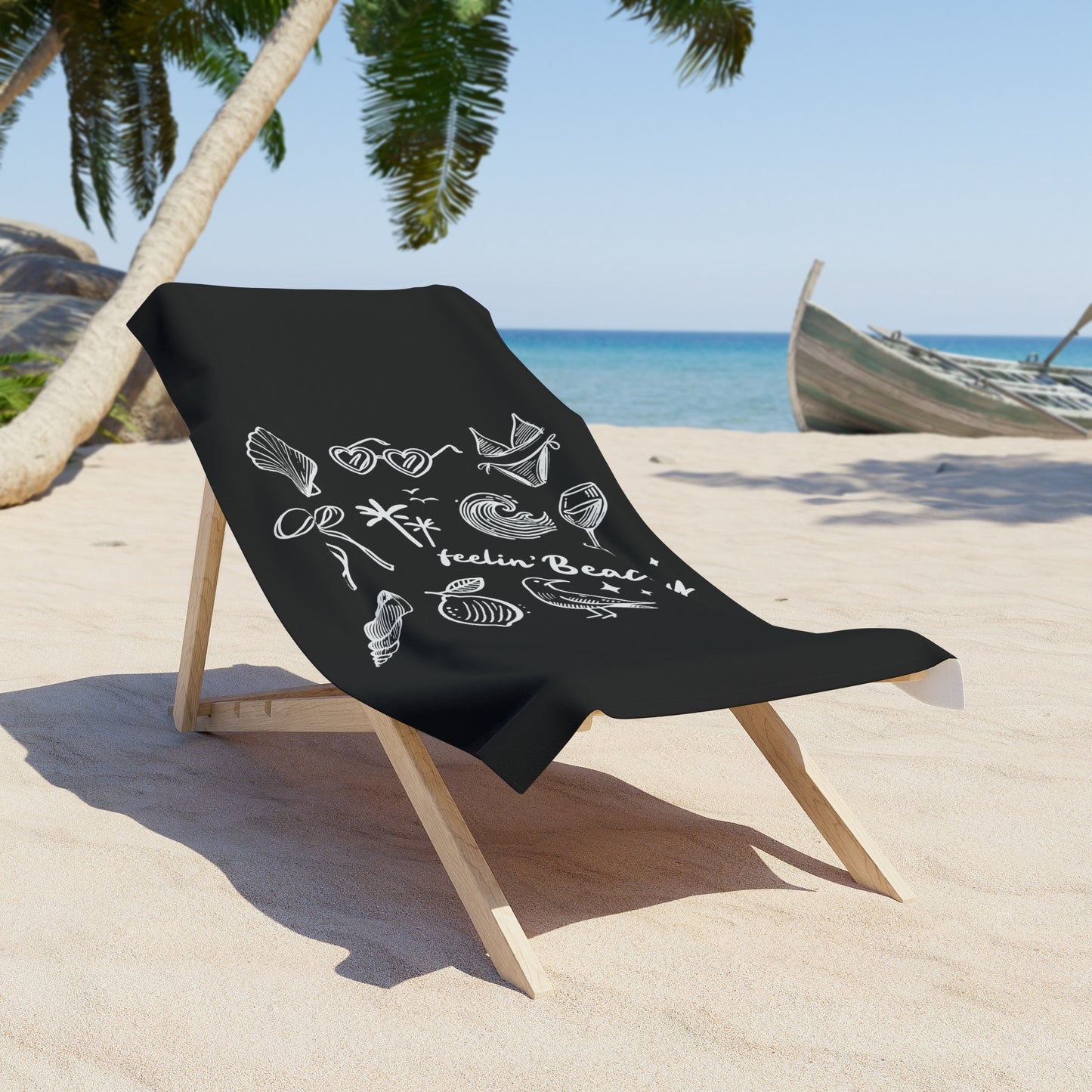 Feelin' Beachy Black & White Doodle Beach Towel displayed on a wooden beach chair on sandy shore