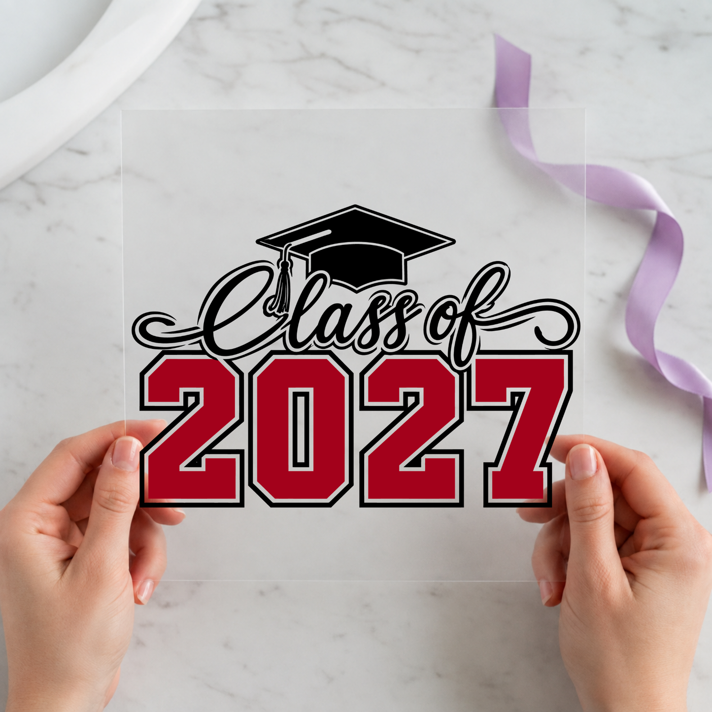 Class of 2027 Graduation Cap featuring black script and red 2027 lettering topped by a graduation cap on a 12x12 ready-to-press DTF heat transfer