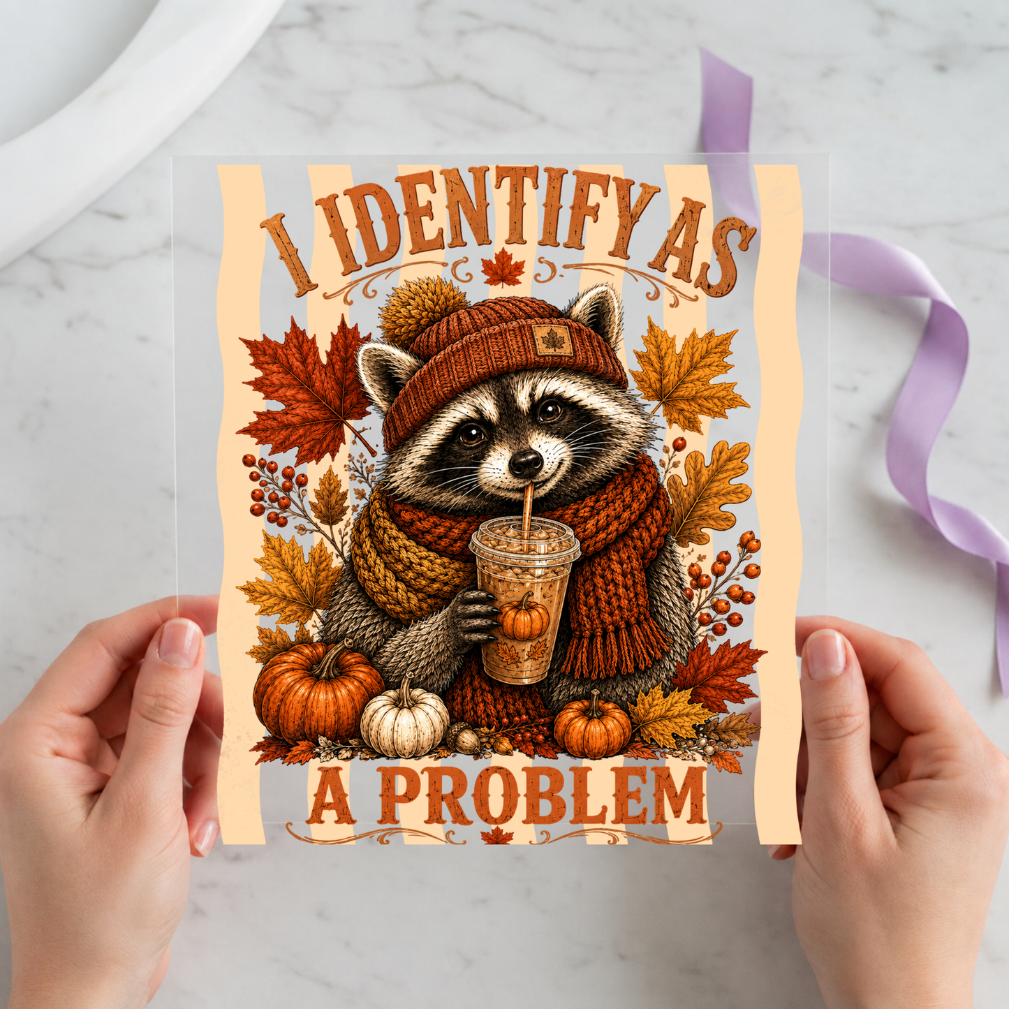 Jimothy the Raccoon I Identify as a Problem featuring cozy Jimothy raccoon in a beanie holding iced coffee among fall leaves on a 12x12 ready-to-press DTF heat transfer