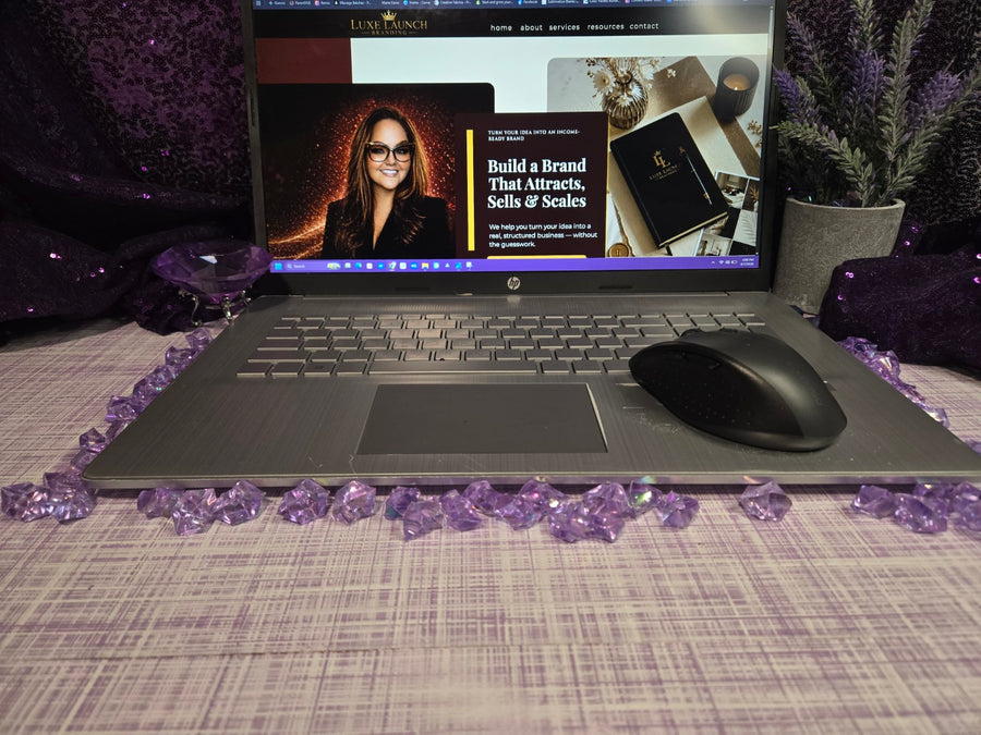 Laptop on a decorative surface with purple accents showing branding and website inspiration