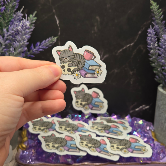 Cozy Goth Cat Sticker - Sleeping Feline on Skull with Books & Daisies - Whimsical Dark Academia Decal