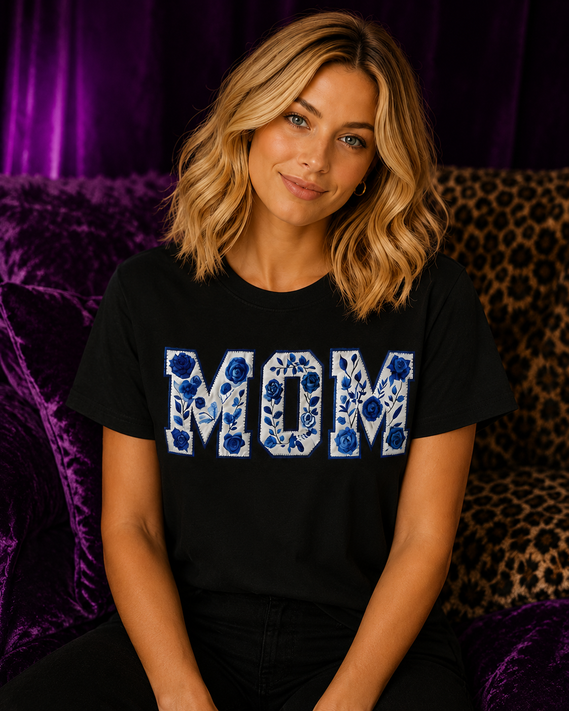Blonde woman wearing a black Gildan Blue Floral Mom T-Shirt with chinoiserie floral lettering in a luxe purple and cheetah print setting