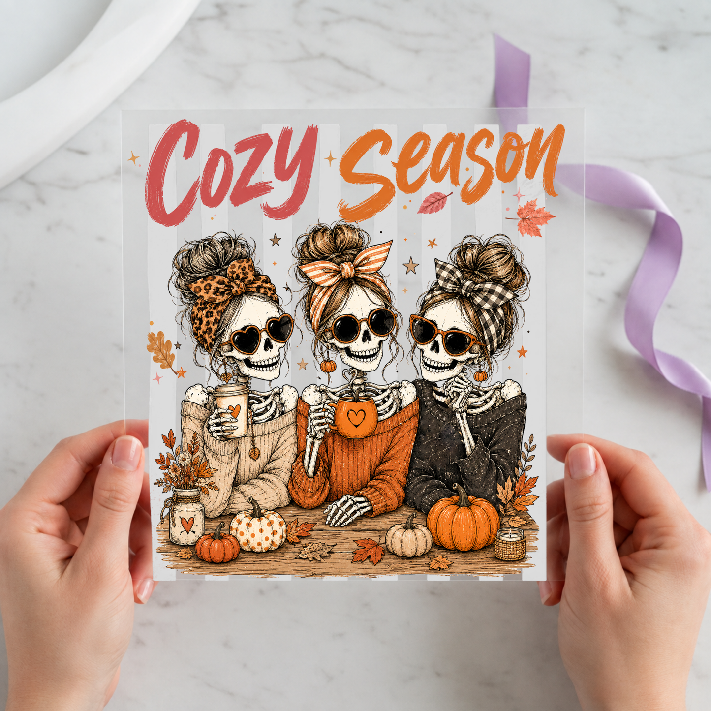 Cozy Season Skeleton Friends featuring three skeleton friends in autumn sweaters holding warm drinks on a 12x12 ready-to-press DTF heat transfer