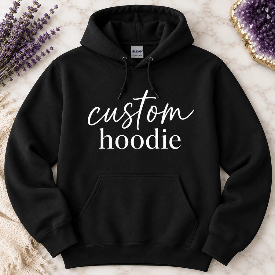 Black pullover custom hoodie with 'custom hoodie' script and serif text design, styled on marble background with dried lavender and amethyst crystal - Marie Gems