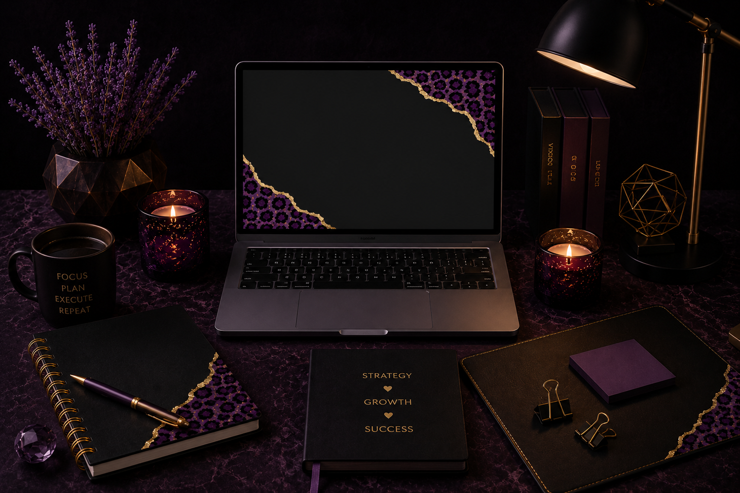 Dark workspace with laptop, candles, notebooks, planner, and pen in purple and gold leopard print accents