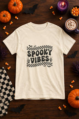Spooky Vibes Retro Checkerboard t-shirt in natural with checkerboard Spooky Vibes graphic, styled flat lay with pumpkins, candy corn, bats and a purple candle
