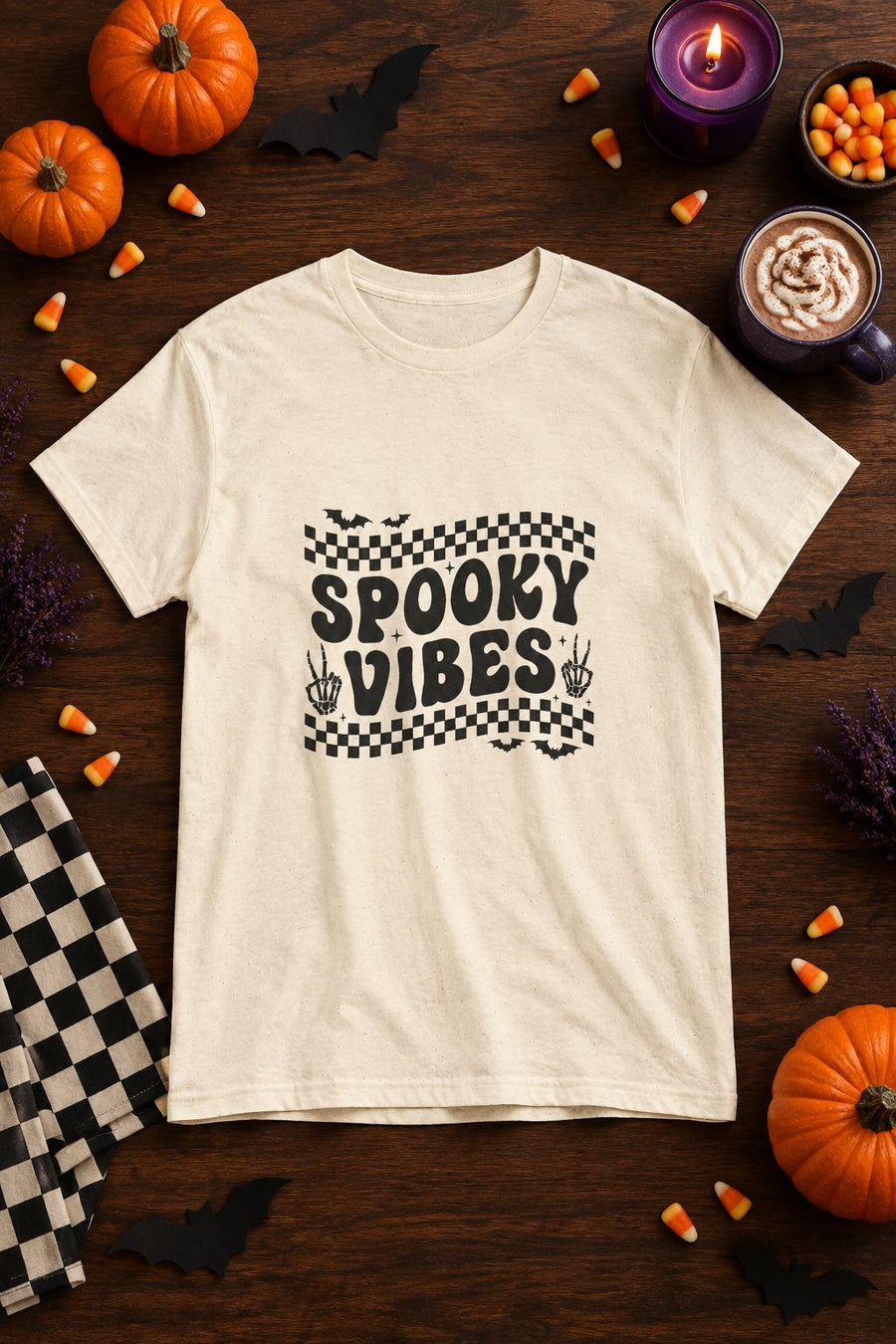 Spooky Vibes Retro Checkerboard t-shirt in natural with checkerboard Spooky Vibes graphic, styled flat lay with pumpkins, candy corn, bats and a purple candle