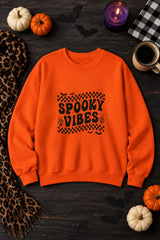 Spooky Vibes Retro Checkerboard crewneck sweatshirt in orange with checkerboard Spooky Vibes graphic, styled flat lay with pumpkins, candy corn, bats and a purple candle