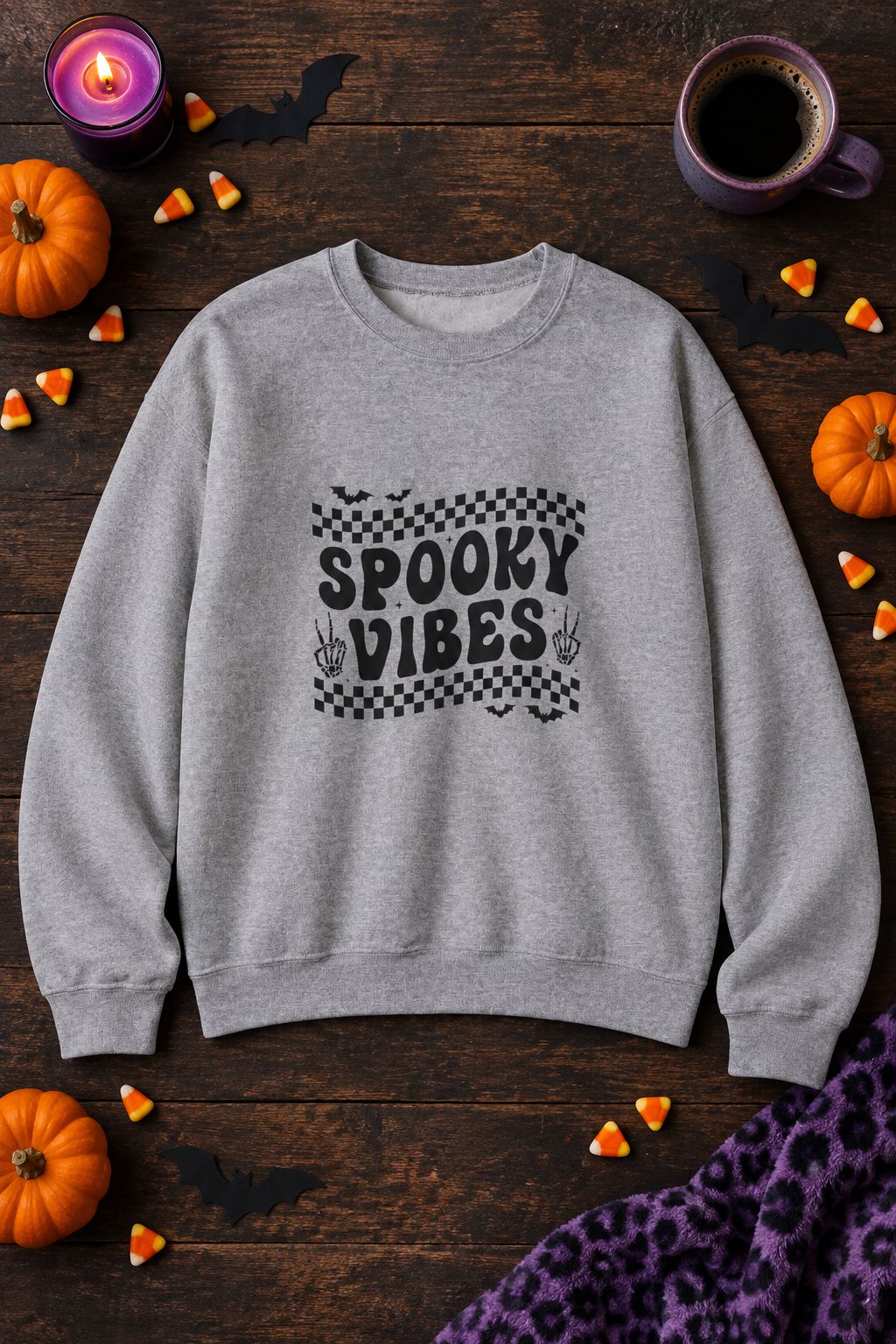 Spooky Vibes Retro Checkerboard crewneck sweatshirt in sport grey with checkerboard Spooky Vibes graphic, styled flat lay with pumpkins, candy corn, bats and a purple candle