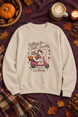 Falling for Fall Literally I'm Clumsy crewneck sweatshirt in sand with goose on a scooter graphic, styled flat lay with a pumpkin basket, plaid scarf, autumn leaves and a latte