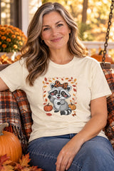 Person wearing the Cute Fall Raccoon t-shirt in natural with leopard bow raccoon graphic in a fall setting