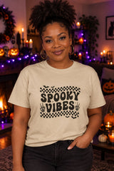 Person wearing the Spooky Vibes Retro Checkerboard t-shirt in sand with checkerboard Spooky Vibes graphic in a fall setting