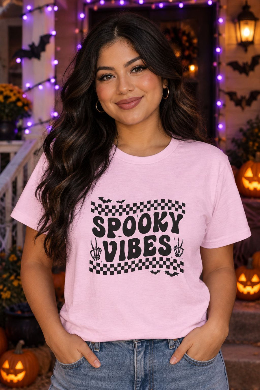 Person wearing the Spooky Vibes Retro Checkerboard t-shirt in light pink with checkerboard Spooky Vibes graphic in a fall setting