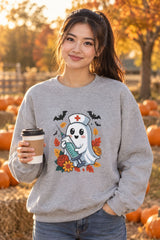 Person wearing the Nurse Ghost Halloween crewneck sweatshirt in sport grey with cute nurse ghost graphic in a fall setting