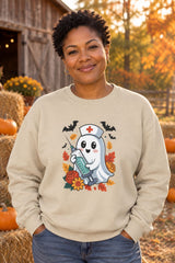 Person wearing the Nurse Ghost Halloween crewneck sweatshirt in sand with cute nurse ghost graphic in a fall setting