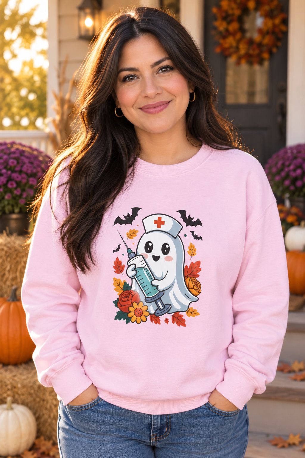 Person wearing the Nurse Ghost Halloween crewneck sweatshirt in light pink with cute nurse ghost graphic in a fall setting