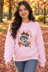 Person wearing the Cute Fall Raccoon crewneck sweatshirt in light pink with leopard bow raccoon graphic in a fall setting