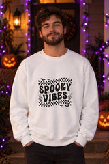 Person wearing the Spooky Vibes Retro Checkerboard crewneck sweatshirt in white with checkerboard Spooky Vibes graphic in a fall setting