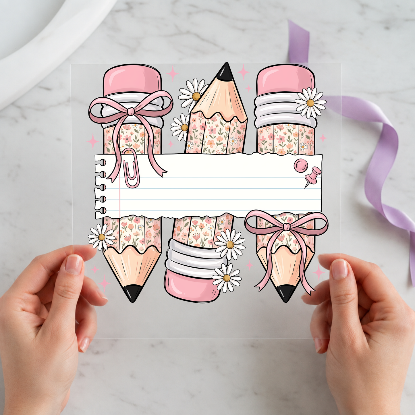 Personalized Pink School Supplies Name Frame featuring pink bows, pencils, crayons, jars and notebooks surrounding a blank name banner on a 12x12 ready-to-press DTF heat transfer